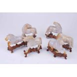 Six 19th century jade horses on carved wooden stands