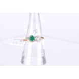 An 18 ct gold emerald and 25 point diamond cross over ring, size R, 4.2g