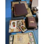 A collection of cigarette cards, vintage writing journal, pictures of fairies and a box of childrens