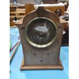 An art nouveau oak and copper inlaid mantle clock.