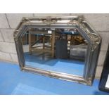 A silver canted top frame wall mirror.