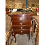 A Edwardian mahogany four drawer music cabinet on stile legs, brass heart shape handles, some music,
