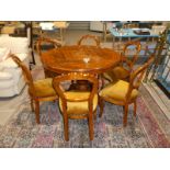 A modern extending circular walnut dining table with a set of 6 balloon back dining chairs.