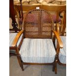 An early 20th century open nursing style armchair with caned back.