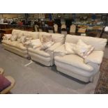 A modern cream leather three piece, three seater suite.