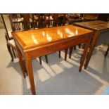 A mahogany fold over top games table with beize surface