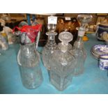 A collection of four glass decanters and a claret jug