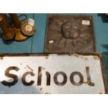 A cast lead sun plaque and a school warning sign