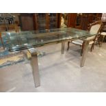 A modern glass and brushed stainless steel draw leaf table