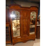 An Edwardian mahogany inlaid two door wardrobe with double arch pediment and feature centre panel
