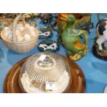 A glazed pottery cockerel and duck, pottery egg basket, two metal coasters and cheese board