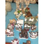 A collection of ceramic ornaments, bisque vases, pottery cottages etc