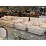 A modern cream leather three piece, three seater suite.