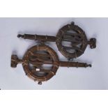 A pair of cast bronze pendant decorative pieces with initials B M set in a wreath 54.5cm x 3cm