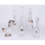 Four assorted lead crystal decanters with plated spirit labels, a further decanter and duck claret