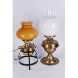 Two brass parafin lamps converted to electricity, one on a wrought iron stand