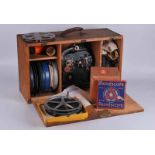 1930s film projector in pine box with a collection of 9.5mm and 16mm film reels of Charlie