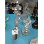Four assorted lead crystal decanters with plated spirit labels, a further decanter and duck claret