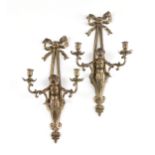 A PAIR OF LOUIS XVI STYLE GILT METAL TWO LIGHT FIGURAL SCONCES, 20TH CENTURY, each with a bow ribbon