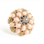 A VINTAGE MODERN PEACH CORAL, SAPPHIRE, DIAMOND, AND 18K YELLOW GOLD BROOCH, with a circular domed