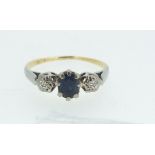 A gold ring set sapphire, flanked by two diamonds - size H