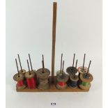 A vintage cotton reel holder and reels