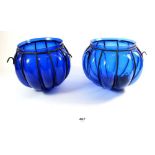 A pair of blue blown glass hanging globes blown into wire frames