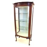 An early 20th century vitrine display cabinet with bow fronted single door all raised on cabriole