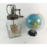 A glass butterchurn and a small globe