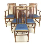 A set of six mid oak Edwardian dining chairs with slat backs (two carvers and four diners)