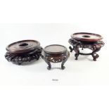 Three carved Chinese hardwood stands, the largest 19cm diameter