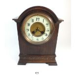 A French oak cased mantel clock with enamel dial, pendulum and key