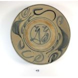 A Chinese provincial pottery dish painted in blue, 28.5 cm diameter