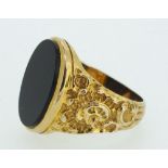 A 9ct gold gentleman's ring with cast scrollwork decoration, inset black onyx, 9.5gm, size X-Y