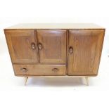 A retro Ercol elm sideboard with three cupboards and a drawer, cutlery drawer within