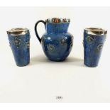 A Royal Doulton blue stoneware jug and two beakers with silver rims, jug 18cm tall