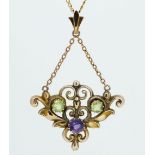 An Edwardian 9ct gold peridot and amethyst scrollwork pendant and chain