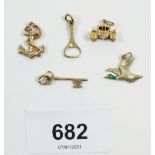 Five 9 carat gold charms comprising key, anchor, carriage, bottle opener and duck