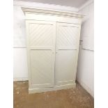 An Edwardian painted pitch pine wardrobe with diagonal panelling and fitted interior