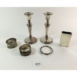 A pair of silver candlesticks, a matchbox cover and two napkin rings - weighable silver 76g