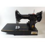 A Singer 221K sewing machine in box with some accessories