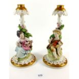 A pair of Capodimonte candlesticks with seated boy and girl, 25cm tall