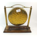 A brass table gong on oak base