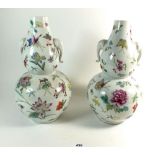 A pair of Chinese famille rose double gourd form vases painted flowers and butterflies, 30cm on