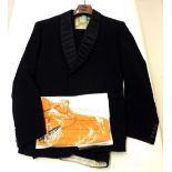 A gentlemen's dinner suit with orange cumberband and bow tie
