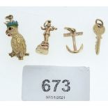 Four 9 carat gold charms comprising parrot, key, anchor and boy with horn 9.4g