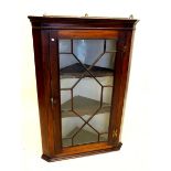 A George III mahogany wall corner cupboard with astragal glazed door and brass butterfly hinges