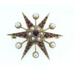 A 9 carat gold garnet and pearl star form brooch, 7.5g, 3.8cm diameter