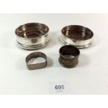 A pair of silver bottle coasters and two silver napkin rings