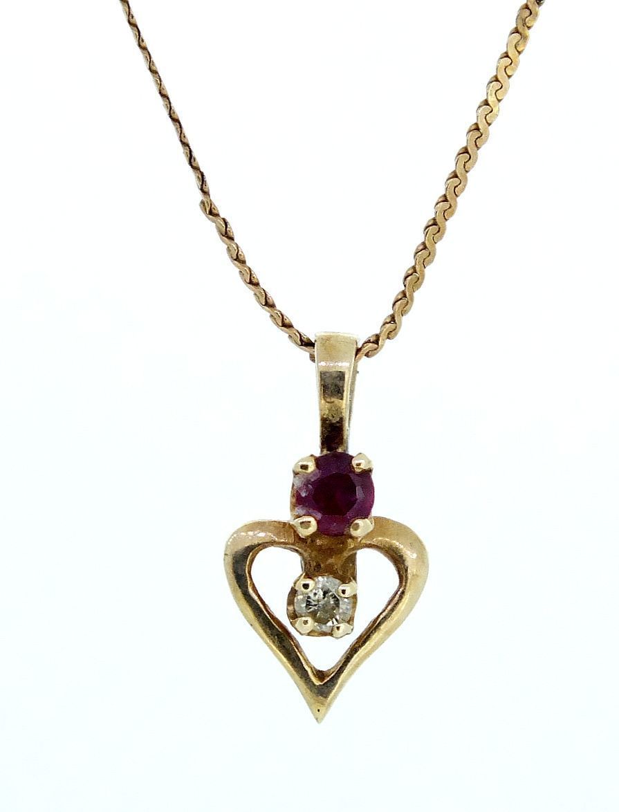 A 10ct gold diamond and ruby set heart form pendant on fine chain